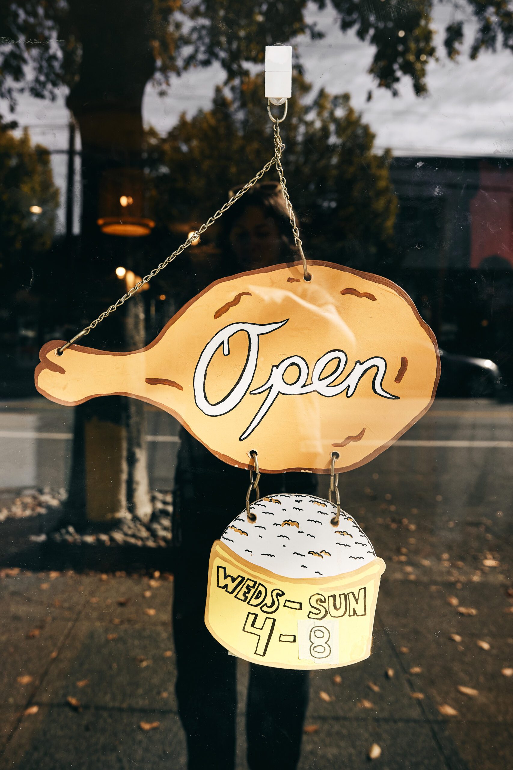 an open sign with hours in a window