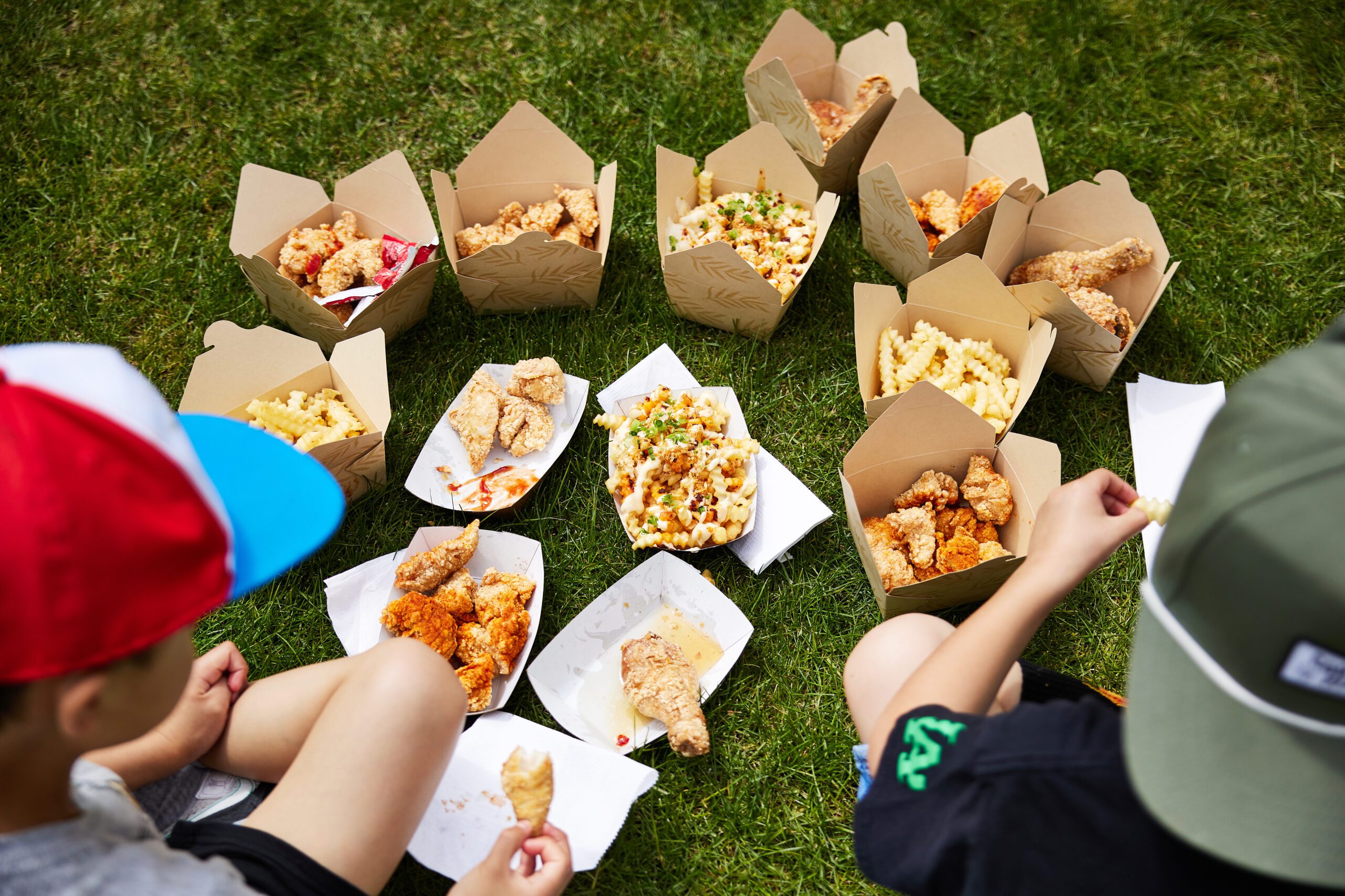to go boxes of food on a lawn in front of two people